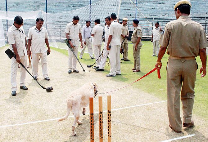 Security personnel with sniffer dog carry out security operations around the pitch at the Barabati Stadium in Cuttack on Sunday