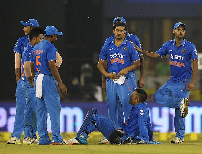 Indian players look on as play is suepended due to the crowd throwing bottles onto the pitch during the second T20 International in Cuttack 