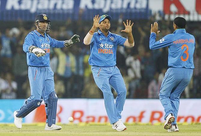 India's captain Mahendra Singh Dhoni (left) and Suresh Raina celebrate the dismissal of South Africa's Farhaan Behardien during their second One-day International match in Indore on Wednesday