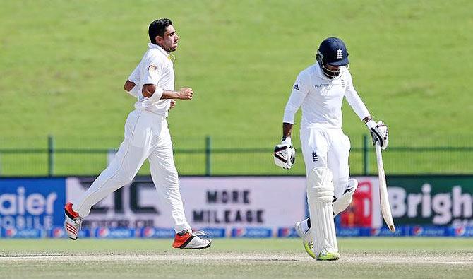 Pakistan's Imran Khan (left) celebrates taking the wicket of England's Adil Rashid during the 1st Test at the Zayed Cricket Stadium, in Abu Dhabi on Friday