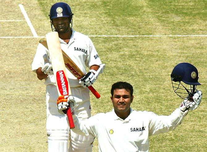 Virender Sehwag (R) of India celebrates reaching his 300 as teammate Sachin Tendulkar  