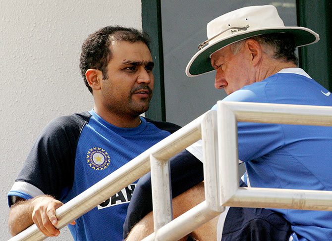 Former India coach Greg Chappell talks with Virender Sehwag after a practice session  