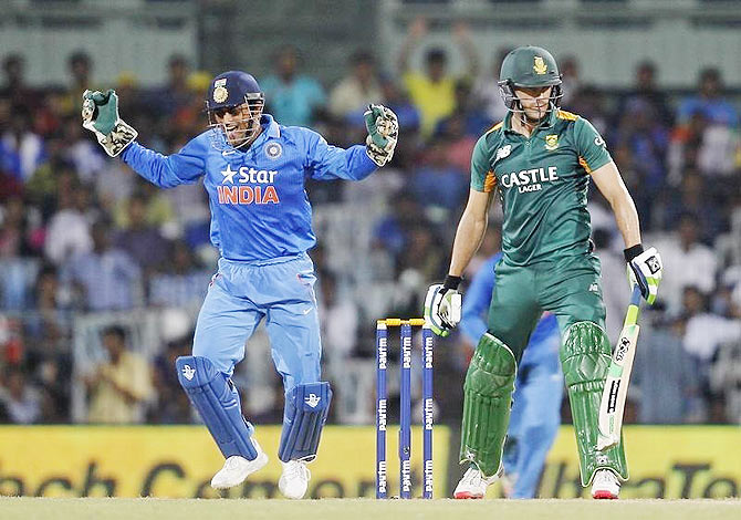 India's captain and wicketkeeper Mahendra Singh Dhoni (left) celebrates after taking the catch to dismiss South Africa's Faf du Plessis during their fourth one-day international cricket match in Chennai on Thursday