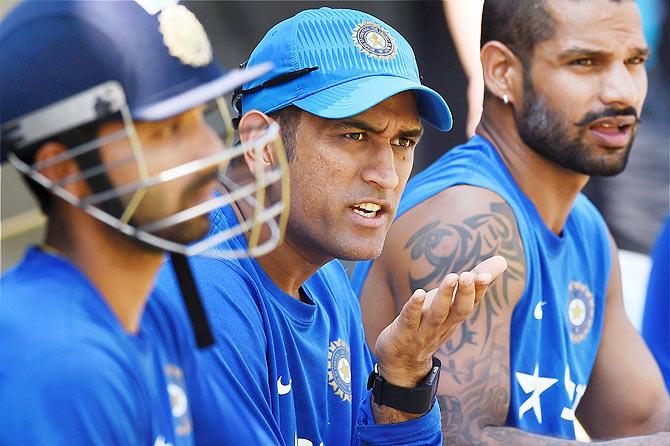 Indian Cricket team captain Mahendra Singh Dhoni talks to teammates Shikhar Dhawan and Ajinkya Rahane during a practice session