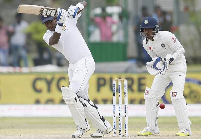  India wicketkeeper Wriddhiman Saha watches closely as Sri Lanka skipper Angelo Mathews plays a shot 