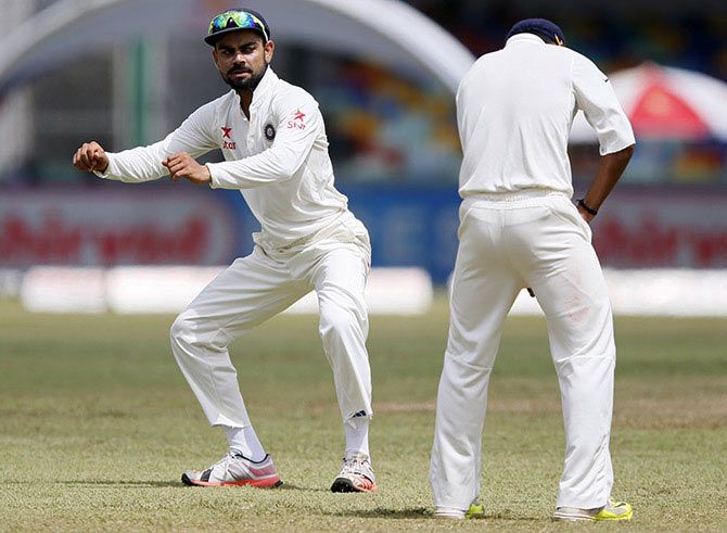 India's captain Virat Kohli (left) stretches as his teammate Ajinkya Rahane shines the ball during the recent Test series in Sri Lanka