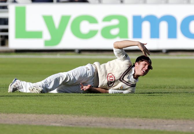 Surrey's Zafar Ansari waves for attention as he injures his hand while fielding on Day 2 of the LV County Championship Division Two match against Lancashire at Emirates Old Trafford in Manchester on Tuesday