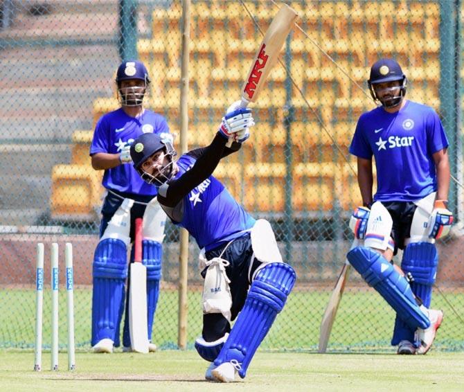 Virat Kohli (centre) bats