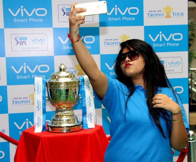 A fan poses with the IPL trophy