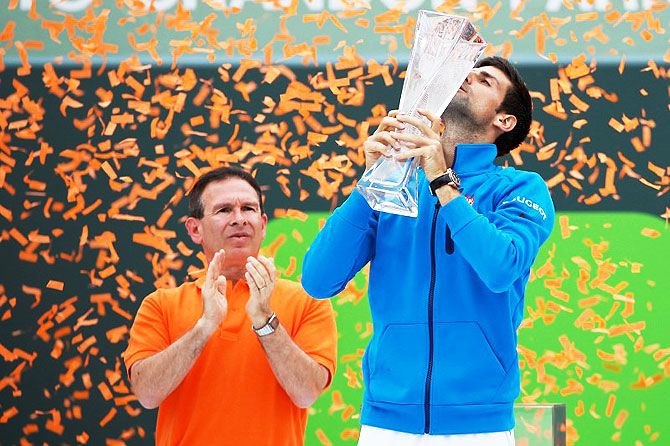 Novak Djokovic celebrates with the Butch Buchholz championship trophy after defeating Kei Nishikori in the men's singles final of the Miami Open at Crandon Park Tennis Center in Key Biscayne, Florida on Sunday