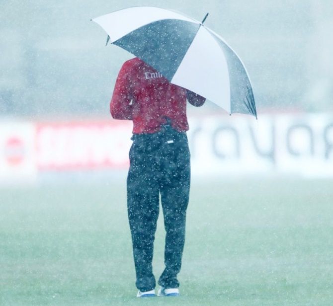 An umpire stands in the rain during the 2nd international T20 Trophy match between India and the West Indies held at the Central Broward Stadium in Fort Lauderdale, Florida