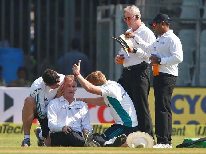 Umpire Paul Reiffel is helped by medical staff during Day 1 of the 4th Test in Mumbai on Thursday