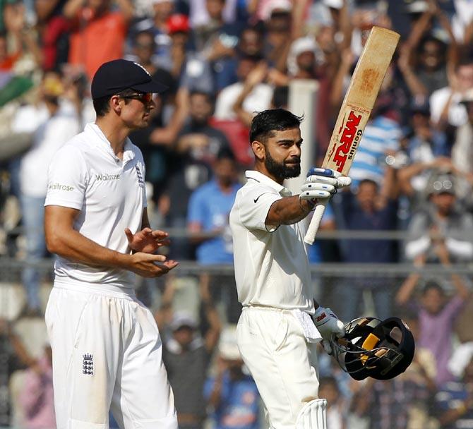 Alastair Cook applauds as Virat Kohli celebrates after completing his century