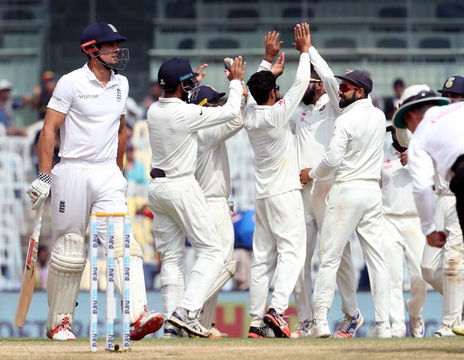  India's players celebrate as Alastair Cook walks back after his dismissal on Day 5 of the 5th Test in Chennai on Tuesday