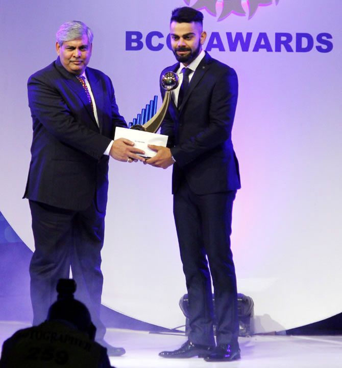 India's Test captain Virat Kohli accepts the Polly Umrigar Trophy for Cricketer of the Year from BCCI president Shashank Manohar