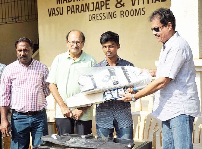 Pranav Dhanawade (centre) is presented with a batting kit by former India captains Dilip Vengsarkar (right) and Ajit Wadekar (2nd from right) during a felicitation ceremony on Wednesday