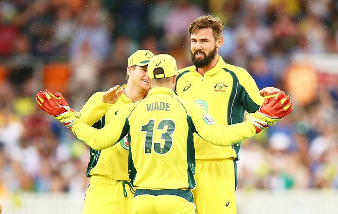 Kane Richardson celebrates with teammates after taking a wicket