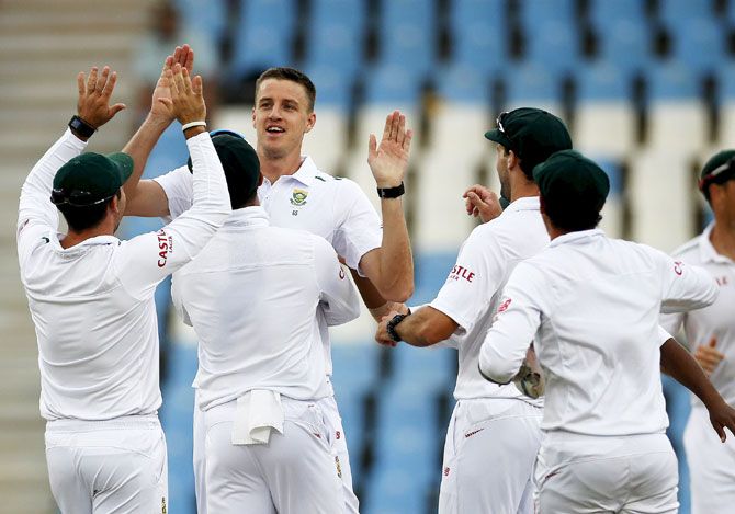 South Africa's Morne Morkel (3rd from left) is congratulated by teammates after he bowled out England's captain Alastair Cook during the fourth Test match at Centurion, in Pretoria on Monday