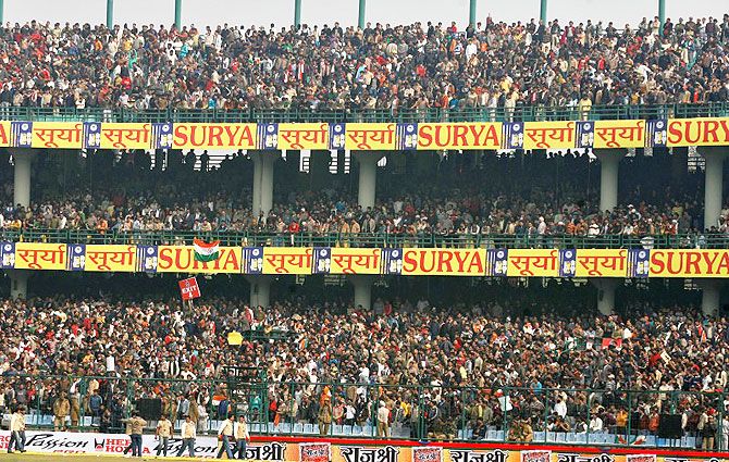 Spectators wait in the stands at Feroz Shah Kotla stadium
