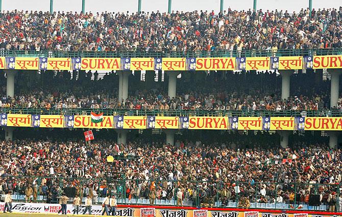 Spectators wait in the stands at Feroz Shah Kotla stadium