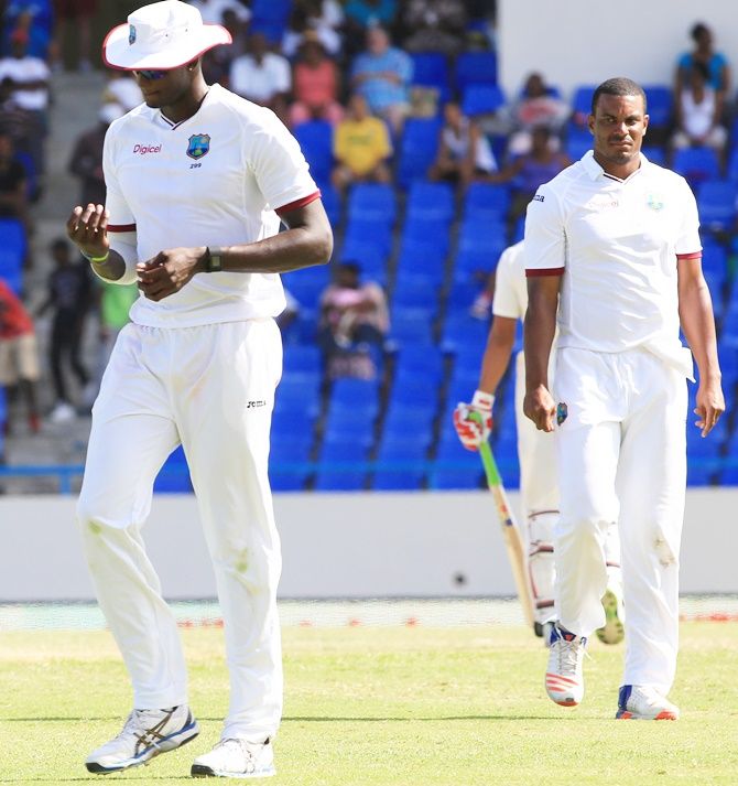 West Indies’ Jason Holder, left, reacts against India in the first Test at Antigua