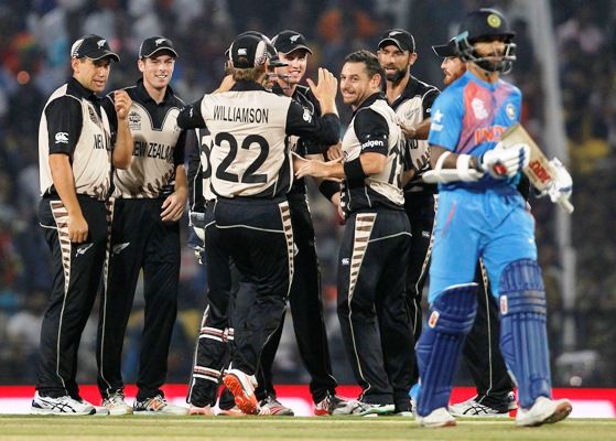 New Zealand's Nathan McCullum, fourth from right, is congratulated by his teammates after dismissing India's Shikhar Dhawan