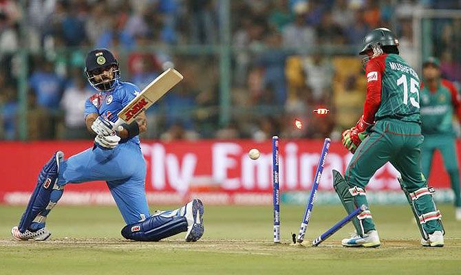 India's Virat Kohli (left) is bowled as Bangladesh's wicketkeeper Mushfiqur Rahim looks on during their Super 10s World T20 match in Bengaluru on Wednesday
