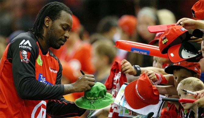 Chris Gayle of the Melbourne Renegades signs autographs for fans during the Big Bash League match against Adelaide Strikers