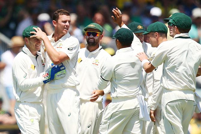 Australia's Josh Hazlewood celebrates with 'keeper Peter Nevill after dismissing South Africa opener Dean Elgar on Day 1 of the first Test at the WACA in Perth, Australia