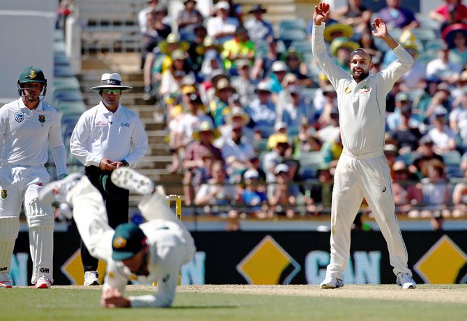 Australia's Nathan Lyon celebrates as he watches teammate Shaun Marsh take a diving catch to dismiss South Africa's Temba Bavuma on Day 1 of the 1st Test at the WACA in Perth Thursday