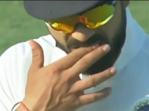 A controversial video grab of Virat Kohli rubbing his fingers to his mouth before applying the saliva to one side of the ball during the first Test in Rajkot on Tuesday