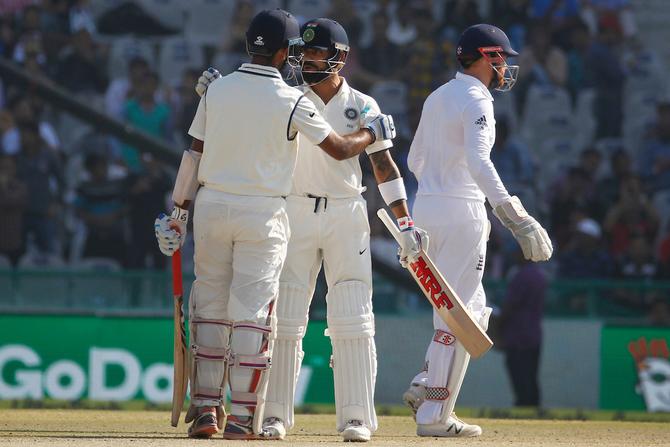  Indian captain Virat Kohli congratulates Cheteshwar Pujara for completing his half century