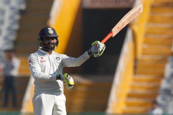 Ravindra Jadeja celebrates his half century, swirling his bat like a sword