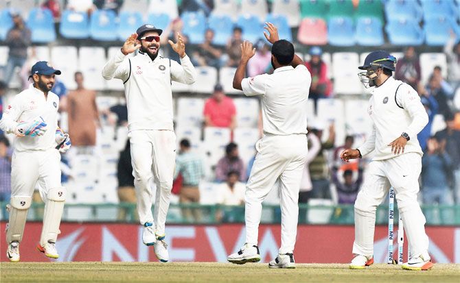 India captain Virat Kohli celebrates with Mohammed Shami after dismissing Chris Woakes on the fourth day of the third Test in Mohali on Tuesday