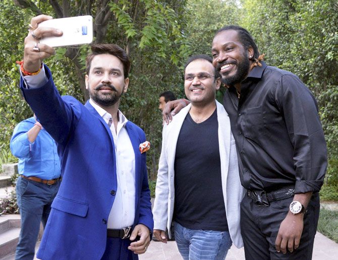 BCCI President Anurag Thakur takes a selfie with former India cricketer Virender Sehwag and West Indies cricketer Chris Gayle at the launch of Gayle's autobiography ‘Six Machine’ in Gurgaon on Friday
