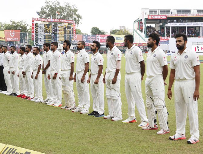 Indian players stand for the national anthem before the opening day's play of the first Test match against New Zealand at the Green Park stadium in Kanpur on Thursday
