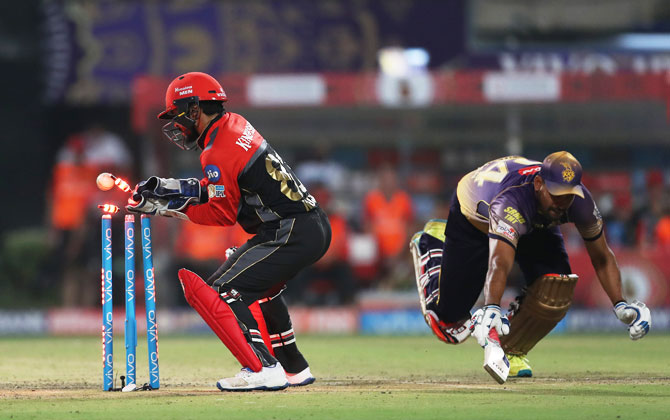 Royal Challengers Bangalore's wicket-keeper Kedar Jadhav attempts to run out Kolkata Knight Riders' Yusuf Pathan