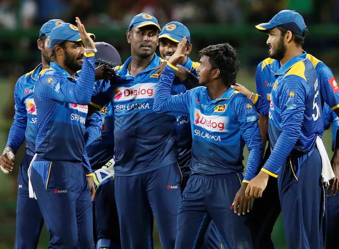 Akila Dananjaya, centre, celebrates with team-mates after picking up the wicket of Axar Patel