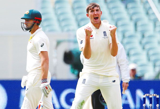 Australia's Shaun Marsh looks on as England's Craig Overton celebrates after dismissing Australia's Tim Paine 