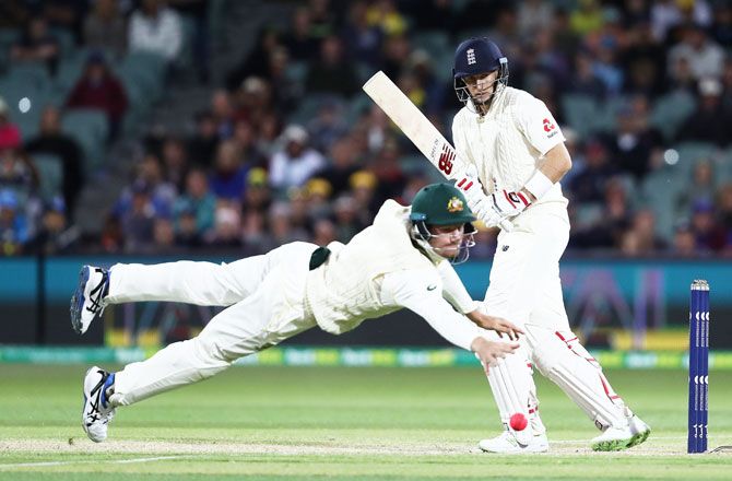 England captain Joe Root bats as Australia's Cameron Bancroft attempts to field the ball