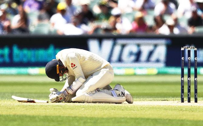 England's Craig Overton reacts after being struck in the rib cage by a delivery from Australia's Pat Cummins