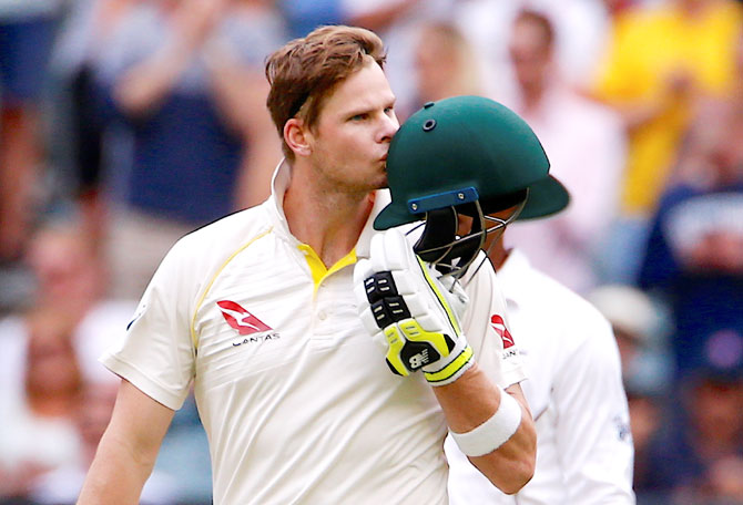 Australia's captain Steve Smith kisses his helmet after reaching his century 