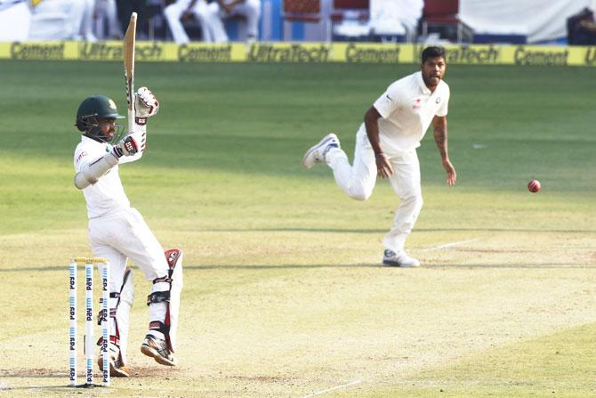 Umesh Yadav watches as Mominul Haque fends off a short delivery