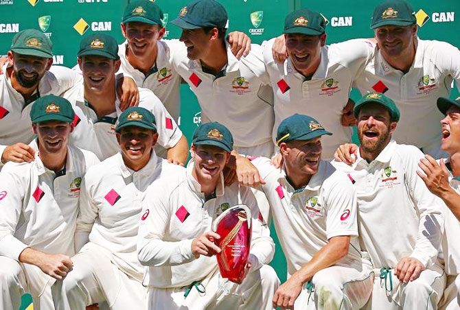 Australia's captain Steve Smith holds the trophy as he poses with teammates after winning the series against Pakistan at the Sydney Cricket Ground on Saturday