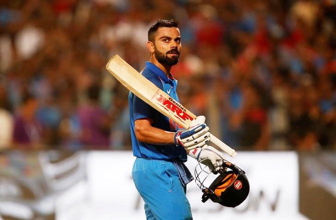 India's captain and centurion Virat Kohli acknowledges the crowd as he walks off the ground after being dismissed during the first ODI against England in Pune on Sunday