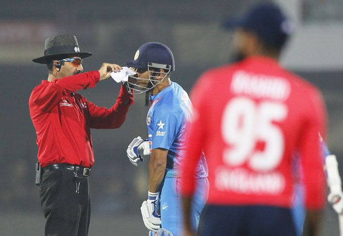 Umpire Anil Chaudhary helps Mahendra Singh Dhoni who was struggling with some dust in his eye