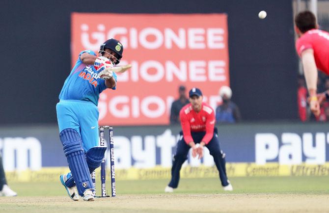 Suresh Raina comes downs the track to smash the ball over Liam Plunkett