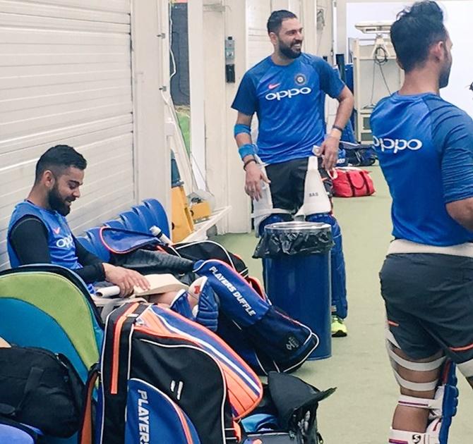 Skipper Virat Kohli chats with Yuvraj Singh before a training session