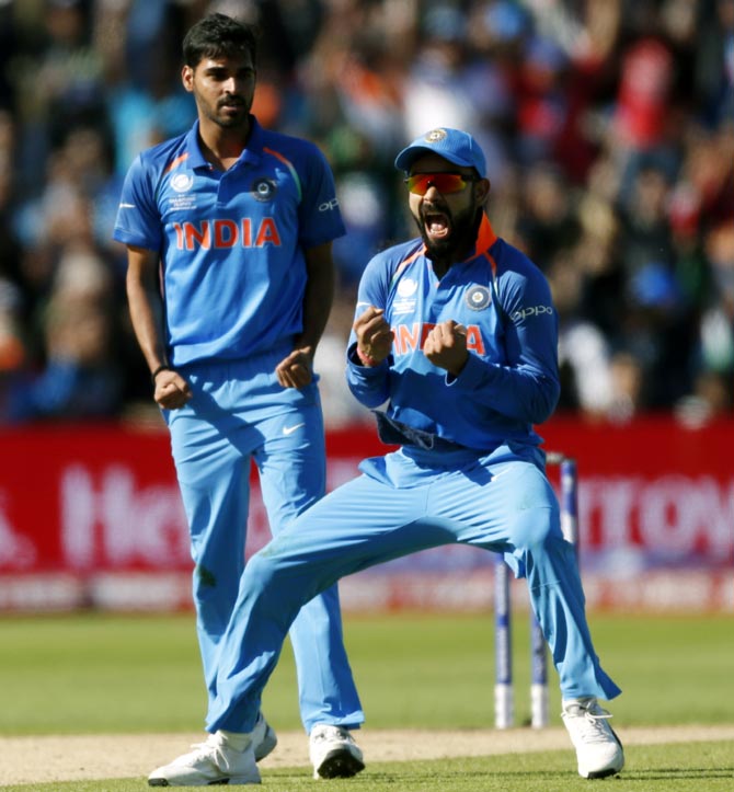 India captain Virat Kohli and Bhuvneshwar Kumar celebrate the wicket of Pakistan's Ahmed Shehzad