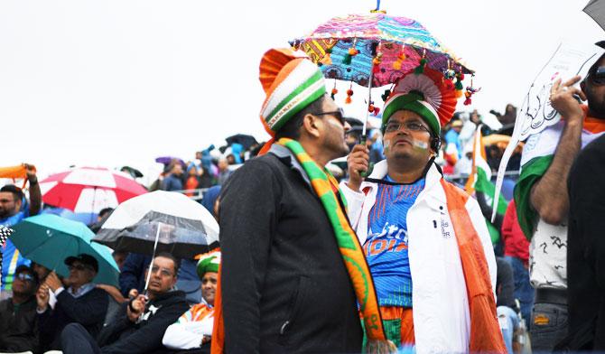 Fans take shelter from the rain